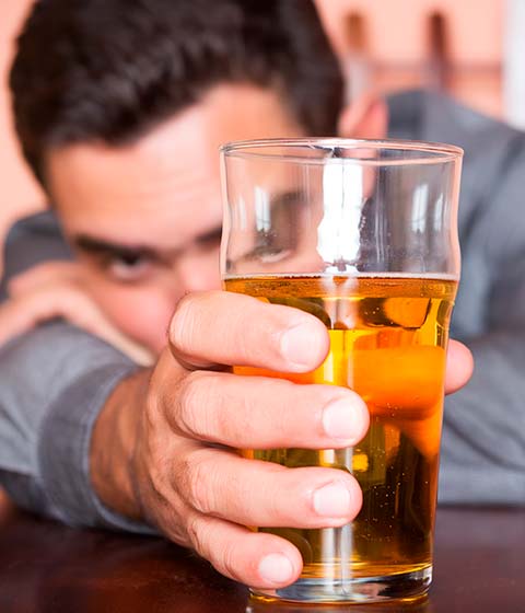 мужчина держит в руке стакан с пивом
